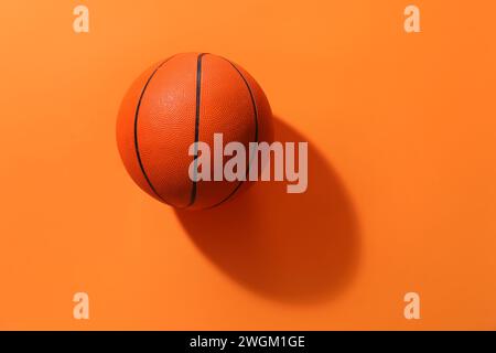 Ballon de basket-ball sur fond orange Banque D'Images