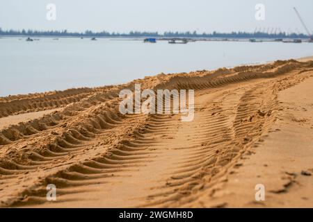 Les ornières de roue des véhicules de construction sur la plage au bord de la mer Banque D'Images