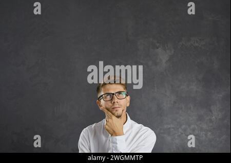 Portrait d'un jeune homme confus et perplexe qui réfléchit soigneusement à quelque chose. Banque D'Images