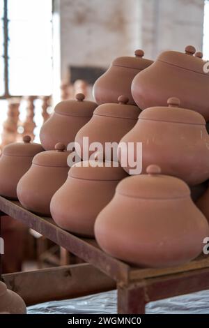 Embryons d'argile soigneusement empilés et moules dans une usine de poterie chinoise traditionnelle Banque D'Images