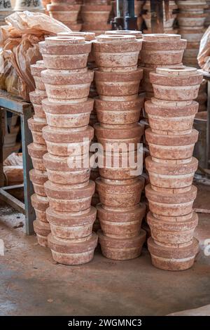 Embryons d'argile soigneusement empilés et moules dans une usine de poterie chinoise traditionnelle Banque D'Images