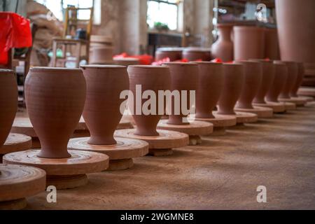 Embryons d'argile soigneusement empilés et moules dans une usine de poterie chinoise traditionnelle Banque D'Images