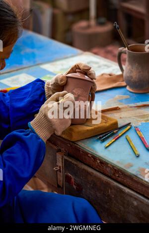 Un artisan fabrique de la porcelaine dans une usine de porcelaine traditionnelle chinoise Banque D'Images