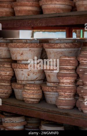 Embryons d'argile soigneusement empilés et moules dans une usine de poterie chinoise traditionnelle Banque D'Images