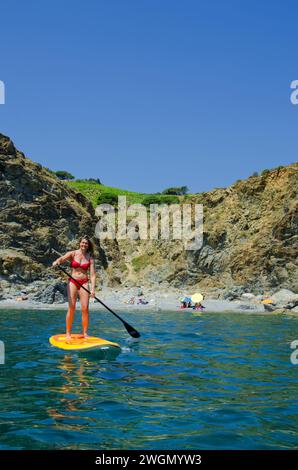 cheveux blonds jolie jeune femme attrayante faisant standup paddle sur l'eau de mer Banque D'Images