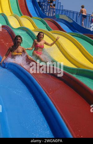 joli cheveux blonds jeune femme profil facesliding sur les vacances de toboggan coloré été drôle visage souriant Banque D'Images