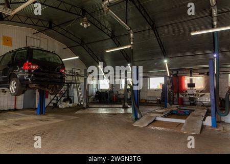 Voiture dans le centre de service de réparation automobile. Station de réparation automobile avec un grand nombre d'ascenseurs et d'équipements spécialisés pour le diagnostic et la réparation de service Banque D'Images