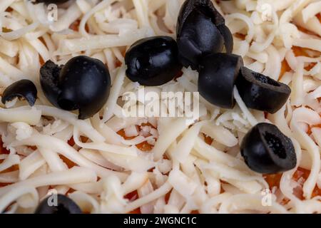 pâte à pizza avec fromage et viande et olives , faire une pizza maison à partir de pâte de blé avec pâte de tomate avec épices fromage viande et olives Banque D'Images