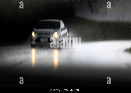 Voiture roulant sur l'autoroute par temps extrême, flou à l'intérieur de l'appareil photo. Banque D'Images