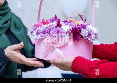 Comme surprise dans leur maison, un homme musulman heureux donne des roses à sa mère Banque D'Images