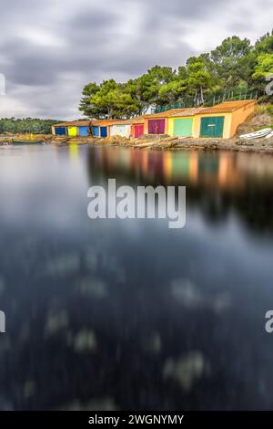 Vue panoramique des abris de bateaux colorés dans le sud de la France sur la fonte pluvieuse pendant l'hiver près de Saint Tropez Banque D'Images