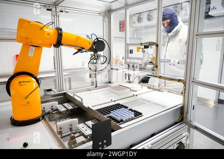 Mannheim, Allemagne. 06th Feb, 2024. Un employé se tient devant un robot pour étiqueter les flacons avec l'ingrédient actif du produit Elevidys pour le traitement de la dystrophie musculaire de Duchenne à l'usine Roche Diagnostics GmbH. La conférence de presse annuelle de Roche Pharma a eu lieu aujourd'hui. Crédit : Uwe Anspach/dpa/Alamy Live News Banque D'Images