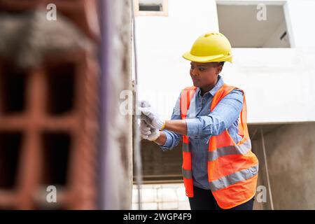 Travail féminin plâtrage sur mur avec mortier Banque D'Images