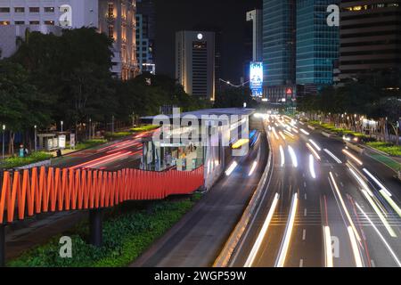 Une image de la circulation du quartier des affaires de Jakarta la nuit avec une longue exposition de mouvement flou et belle traînée de lumière. Voitures et bus. Banque D'Images
