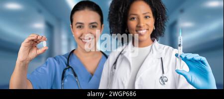Deux professionnels de la santé heureux dans un hôpital, l'un tenant des médicaments Banque D'Images