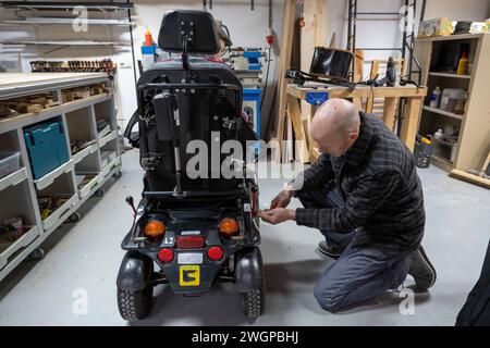 Mécanicien travaillant sur le prototype de fauteuil roulant MAN Banque D'Images