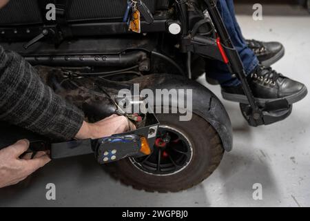 Mécanicien travaillant sur le prototype de fauteuil roulant MAN Banque D'Images