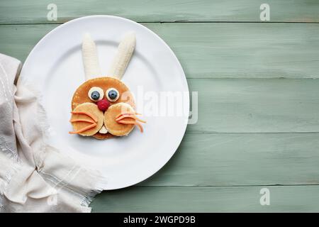 Lapin crêpe créatif amusant et coloré pour les enfants avec banane, bleuets, carottes et framboises pour encourager les enfants à manger des aliments sains. Banque D'Images