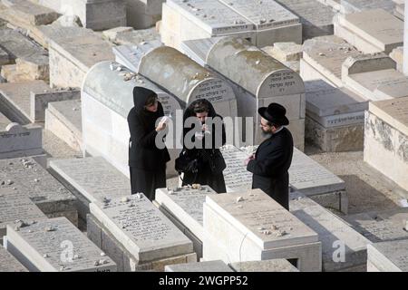 Juifs orthodoxes priant dans le cimetière sur le Mont olivier à Jérusalem, Israël Banque D'Images