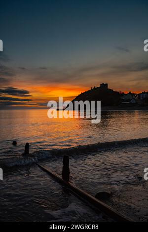 Château de Denbigh et plage au coucher du soleil Banque D'Images