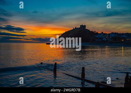 Château de Denbigh et plage au coucher du soleil Banque D'Images