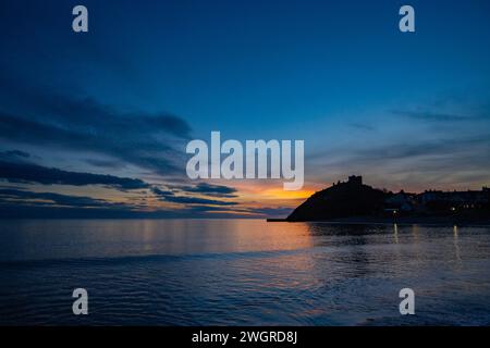 Château de Denbigh et plage au coucher du soleil Banque D'Images