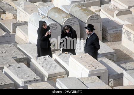 Juifs orthodoxes priant dans le cimetière sur le Mont olivier à Jérusalem, Israël Banque D'Images