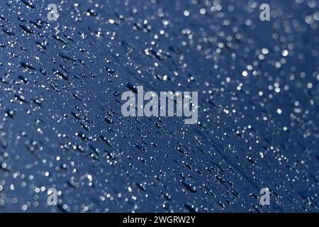 Gouttes d'eau sur la surface métallique bleue. Fond de gouttes d'eau bleu abstrait. Banque D'Images
