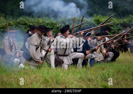 Des reconstituteurs historiques jouent un combat de guerre révolutionnaire entre les Red Coats britanniques et les rebelles américains à Old Sturbridge Village à Sturbridge, au Missouri Banque D'Images