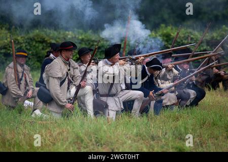 Des reconstituteurs historiques jouent un combat de guerre révolutionnaire entre les Red Coats britanniques et les rebelles américains à Old Sturbridge Village à Sturbridge, au Missouri Banque D'Images