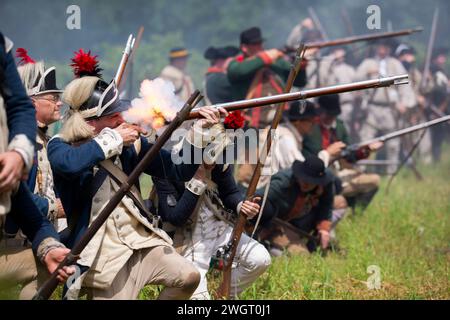 Des reconstituteurs historiques jouent un combat de guerre révolutionnaire entre les Red Coats britanniques et les rebelles américains à Old Sturbridge Village à Sturbridge, au Missouri Banque D'Images