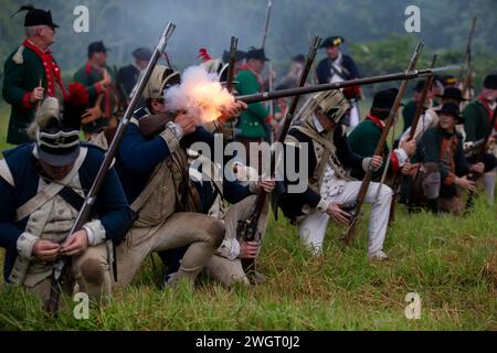 Des reconstituteurs historiques jouent un combat de guerre révolutionnaire entre les Red Coats britanniques et les rebelles américains à Old Sturbridge Village à Sturbridge, au Missouri Banque D'Images