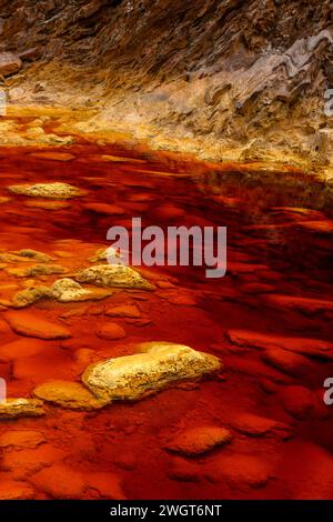 Les eaux rouges extraordinaires du Rio Tinto coulent le long de falaises rocheuses abruptes, mettant en valeur l'art unique de la nature. Banque D'Images