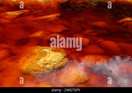 Les eaux rouges extraordinaires du Rio Tinto coulent le long de falaises rocheuses abruptes, mettant en valeur l'art unique de la nature. Banque D'Images