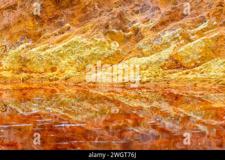 Les eaux rouges extraordinaires du Rio Tinto coulent le long de falaises rocheuses abruptes, mettant en valeur l'art unique de la nature. Banque D'Images