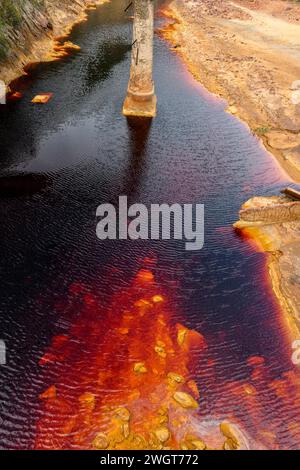 Les eaux rouges extraordinaires du Rio Tinto coulent le long de falaises rocheuses abruptes, mettant en valeur l'art unique de la nature. Banque D'Images