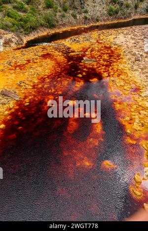 Les eaux rouges extraordinaires du Rio Tinto coulent le long de falaises rocheuses abruptes, mettant en valeur l'art unique de la nature. Banque D'Images