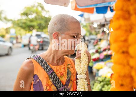 Femme d'âge moyen voyageur solo dans un marché aux fleurs dans le nord de la Thaïlande Banque D'Images