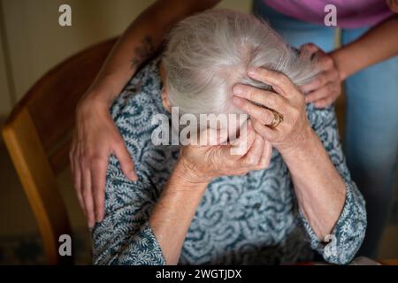 Dame âgée bouleversée d'être réconfortée par elle aidée. Dévasté, pleurant, Banque D'Images