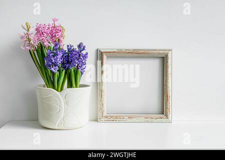 Cadre photo maquette en bois et jacinthe fleurie sur un fond de table blanc Banque D'Images
