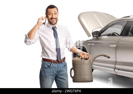 Homme avec un SUV tenant une cartouche d'essence et utilisant un smartphone isolé sur fond blanc Banque D'Images