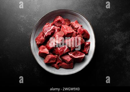 Entrecôte de viande de boeuf tranchée, filet de viande de boeuf crue sur fond noir, vue de dessus Banque D'Images
