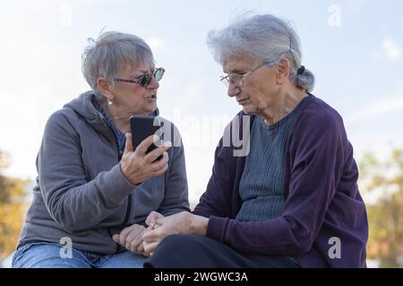 deux dames âgées discutant de l'application smartphone Banque D'Images