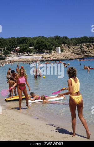 2 jeunes femmes aux cheveux blonds jouant au tennis sur le ciel bleu de la plage et le fond de la plage Banque D'Images