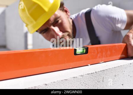 profession ouvrier de la construction - travail sur un chantier construction d'une maison d'habitation - contrôle de la qualité Banque D'Images