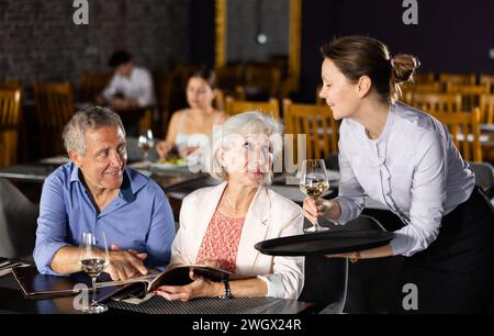 Femme serveur prenant la commande d'un couple âgé au restaurant Banque D'Images
