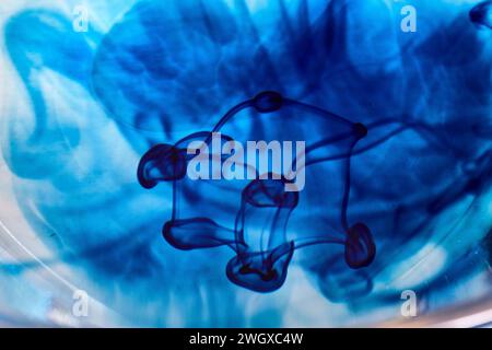Encre bleue tourbillonne dans l'eau - fond artistique abstrait Banque D'Images