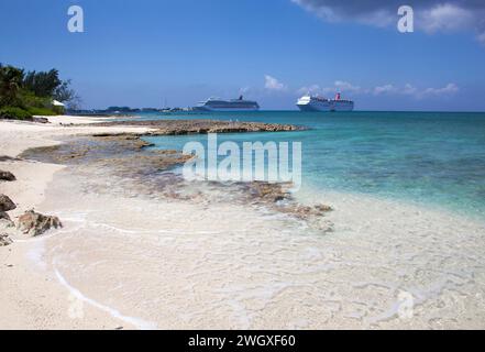 La vue panoramique sur la célèbre île de Grand Cayman Seven Mile Beach et les bateaux de croisière dérivants près de George Town au centre-ville en arrière-plan (îles Caïmans). Banque D'Images