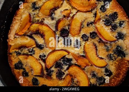 Vue de haut en bas de la pêche de mûre Flaugnarde (semblable à Clafoutis) dans une casserole en fonte Banque D'Images