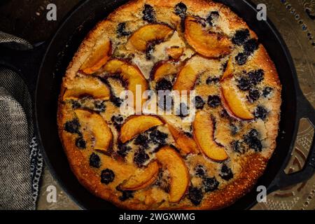 Vue de haut en bas de la pêche de mûre Flaugnarde (semblable à Clafoutis) dans une casserole en fonte Banque D'Images